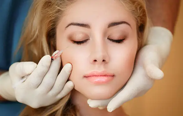 Provider performing a facial treatment with gloved hands