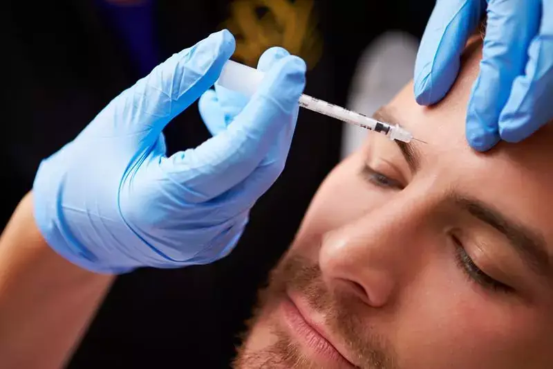 Man receiving a Botox injection in his forehead