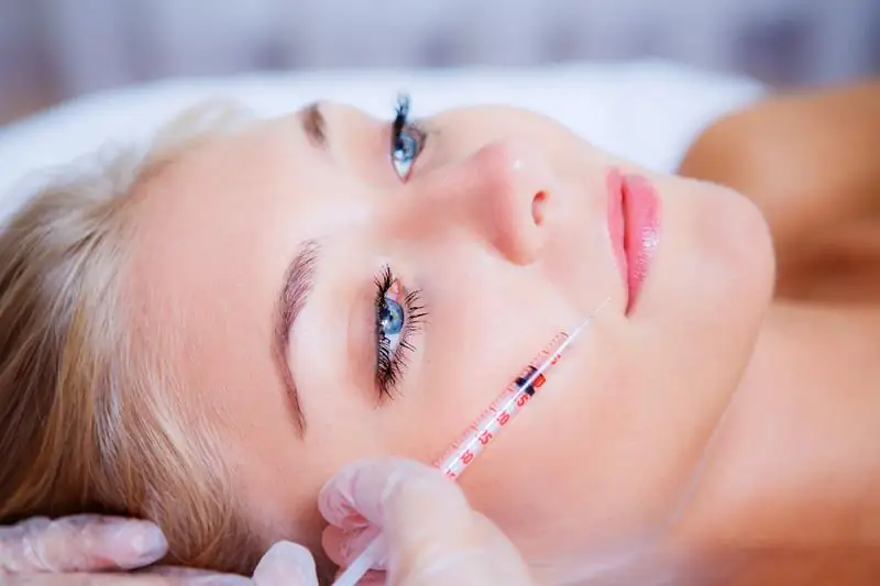 Woman receiving a lip filler injection