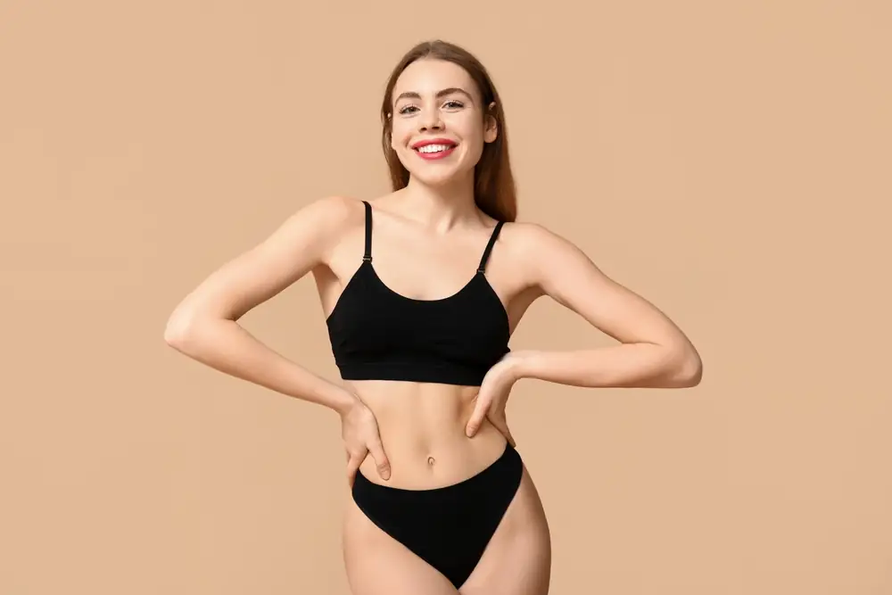 Smiling woman in athletic wear after medical weight loss in Boca Raton