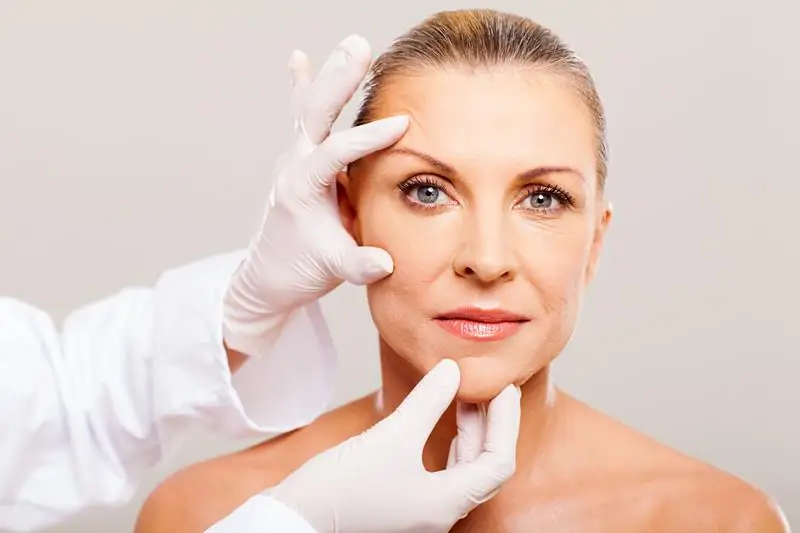 Provider examining a woman's skin before skin rejuvenation