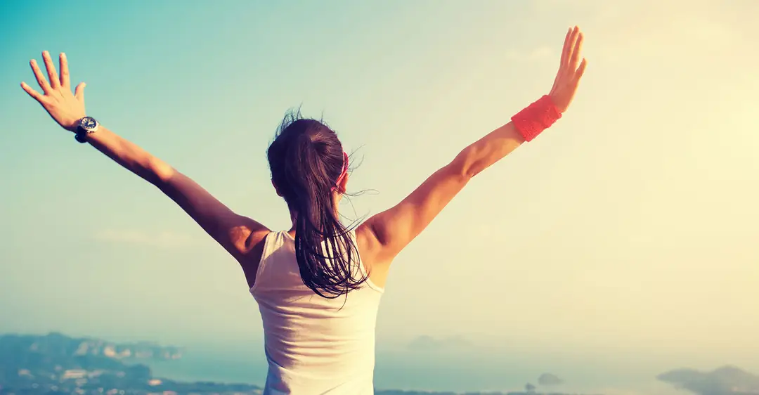 Woman raising her arms on the beach